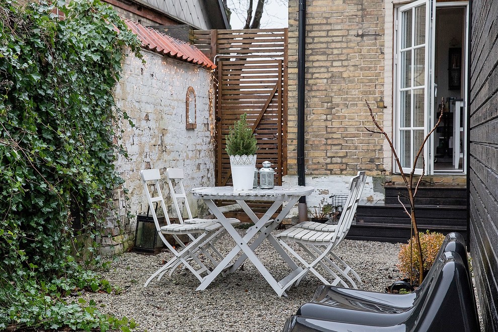 На фото: маленький двор на заднем дворе в скандинавском стиле с покрытием из гравия для на участке и в саду с