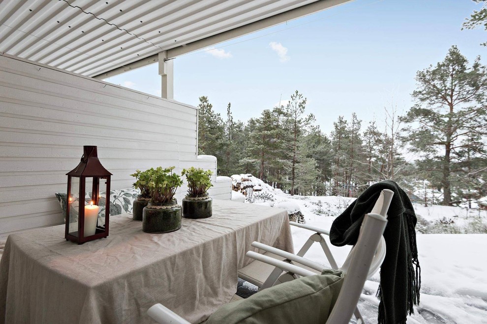 Inspiration pour une terrasse arrière nordique avec une extension de toiture.