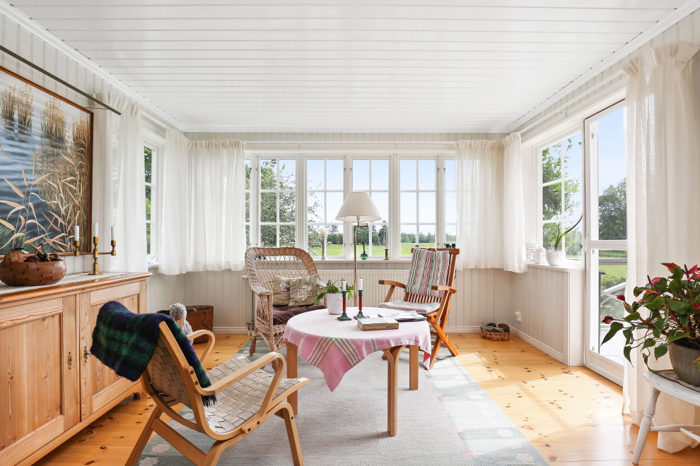 Foto di una veranda scandinava di medie dimensioni con pavimento in legno massello medio, nessun camino, soffitto classico e pavimento beige