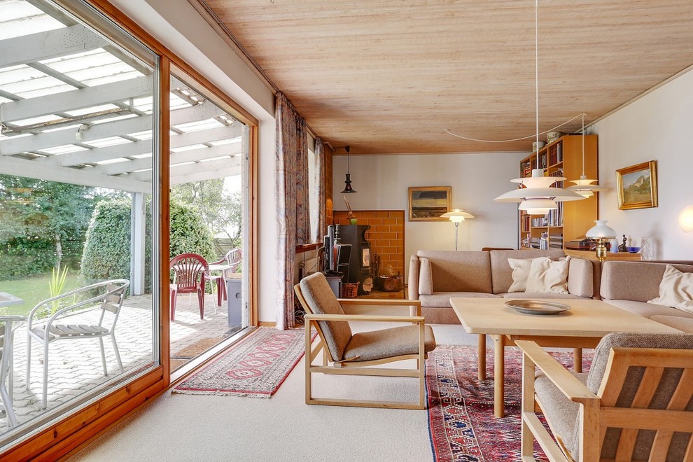 Immagine di una veranda scandinava di medie dimensioni con moquette, soffitto classico, stufa a legna e cornice del camino in mattoni
