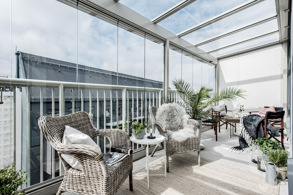 Esempio di una veranda scandinava di medie dimensioni con soffitto in vetro e pavimento grigio