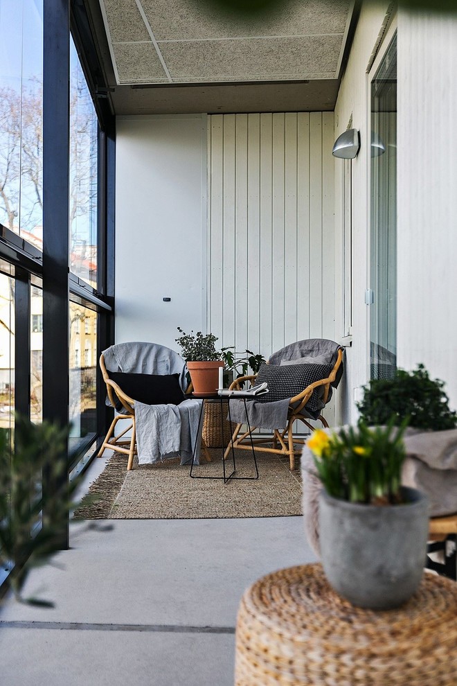 Medium sized scandinavian conservatory in Stockholm with concrete flooring and grey floors.