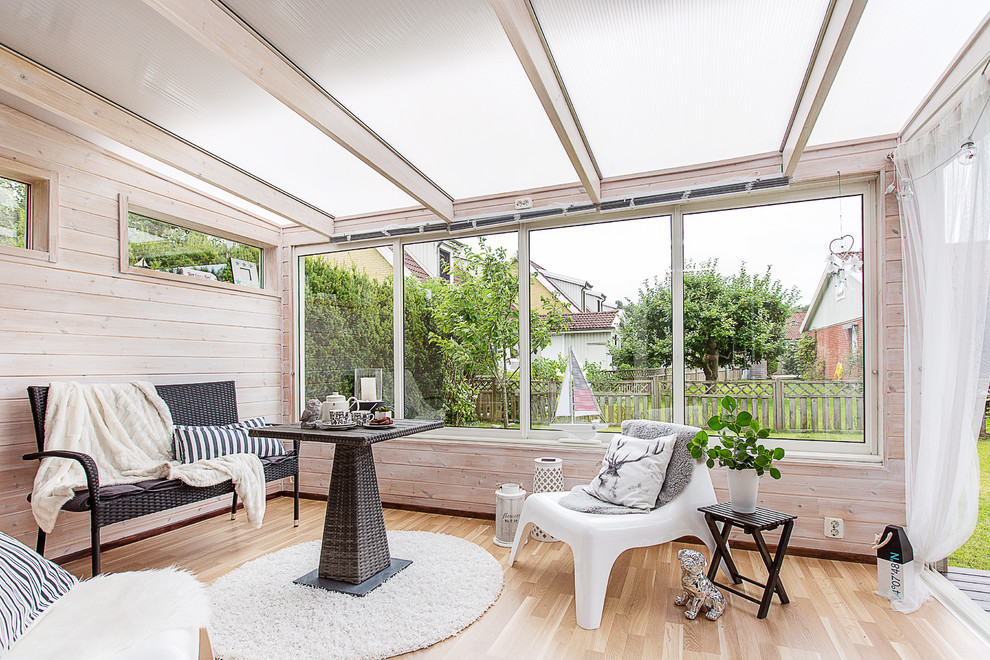 Inspiration for a medium sized scandi conservatory in Gothenburg with light hardwood flooring and a glass ceiling.