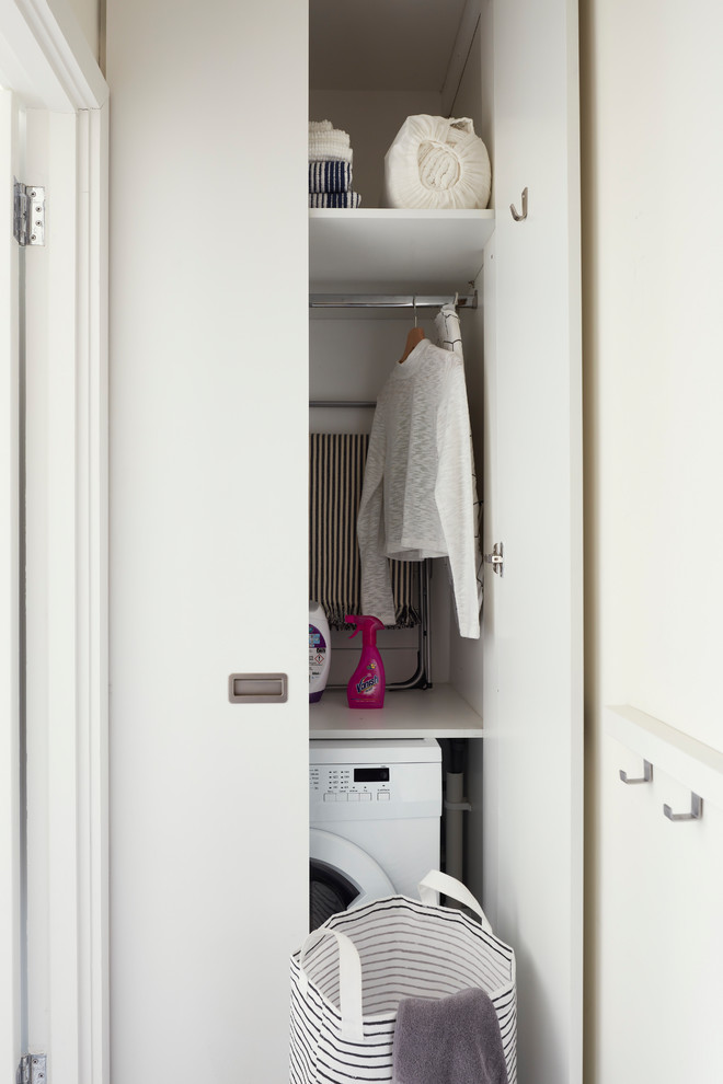 Idéer för att renovera en liten skandinavisk linjär liten tvättstuga med garderob, med släta luckor, vita skåp, vita väggar, vinylgolv och vitt golv