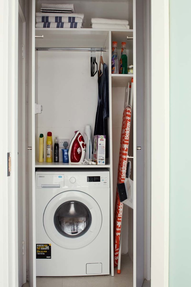 Diseño de lavadero actual pequeño con armarios con paneles lisos, puertas de armario blancas y paredes blancas