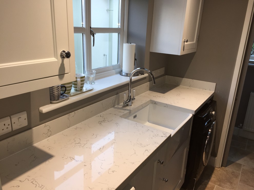 Photo of a small traditional galley utility room in Wiltshire with a belfast sink, engineered stone countertops and grey walls.