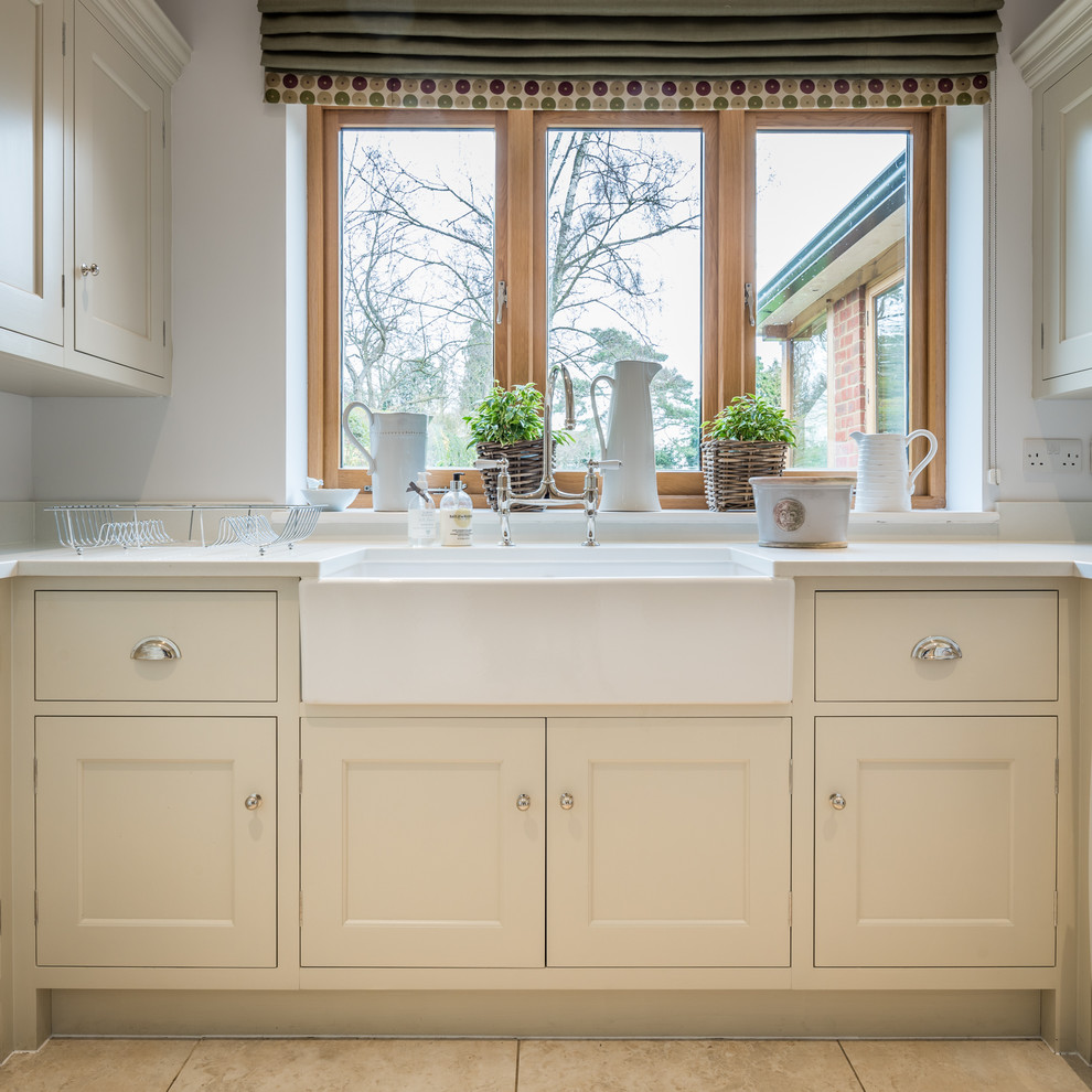 Example of a small farmhouse u-shaped ceramic tile and beige floor utility room design in Hertfordshire with a farmhouse sink, beaded inset cabinets, gray cabinets, quartzite countertops, gray walls, a side-by-side washer/dryer and white countertops