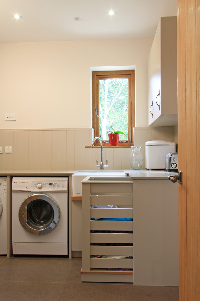 Large contemporary l-shaped utility room in Hampshire with a submerged sink, flat-panel cabinets, beige cabinets, engineered stone countertops, white walls, porcelain flooring and a side by side washer and dryer.
