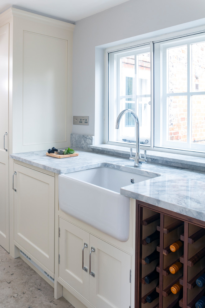 Design ideas for a large classic u-shaped utility room in Wiltshire with a submerged sink, shaker cabinets, beige cabinets, marble worktops, limestone flooring, beige floors and grey worktops.