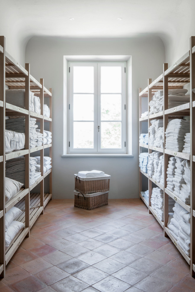 Idéer för stora lantliga parallella tvättstugor enbart för tvätt, med öppna hyllor, skåp i ljust trä, vita väggar och klinkergolv i keramik