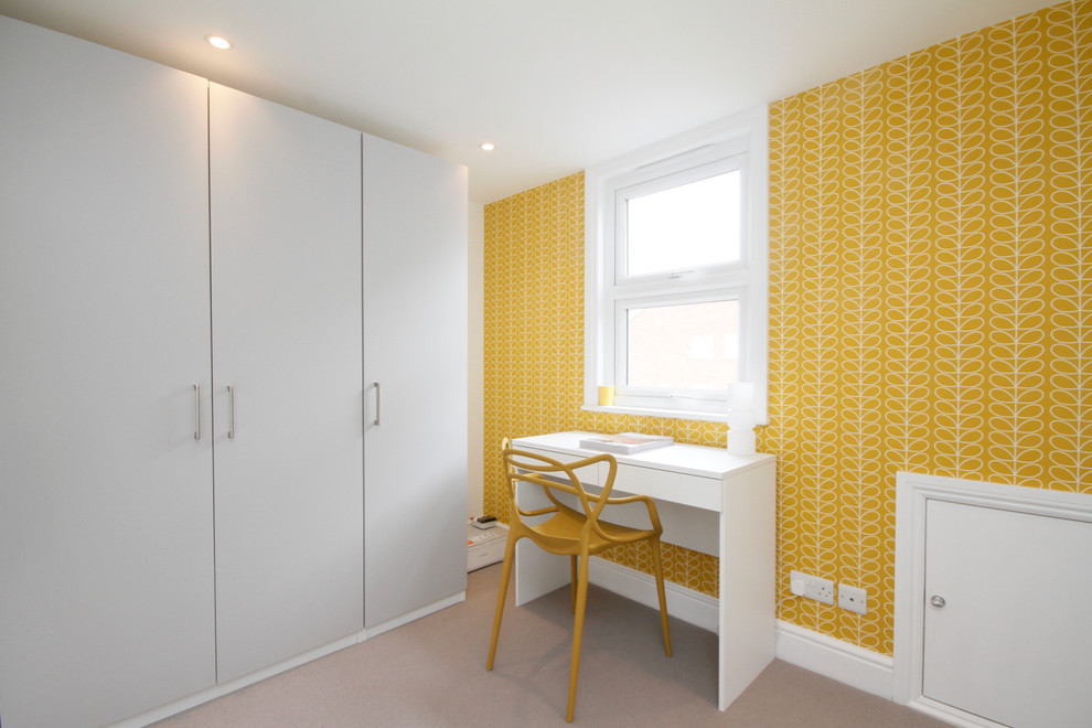 Стильный дизайн: универсальная комната среднего размера с фасадами цвета дерева среднего тона, оранжевыми стенами и ковровым покрытием - последний тренд