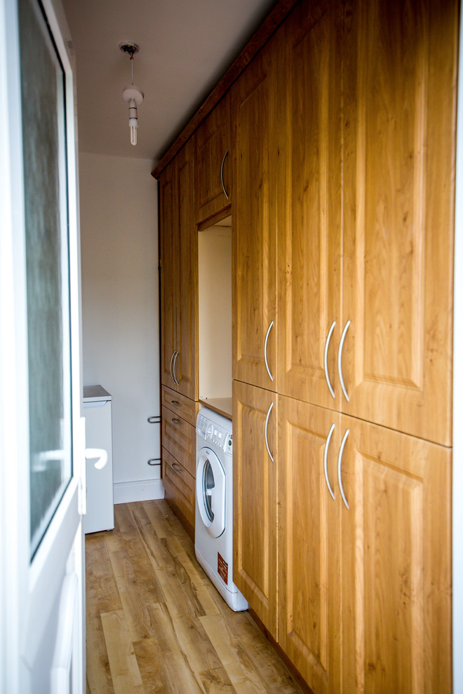 Foto di una sala lavanderia classica con ante in legno chiaro, top in legno, pareti bianche, parquet chiaro e lavatrice e asciugatrice affiancate
