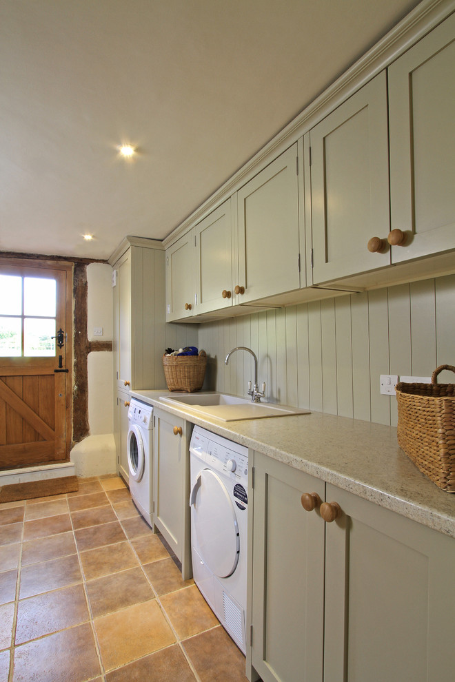 Landhausstil Hauswirtschaftsraum mit Einbauwaschbecken, Schrankfronten im Shaker-Stil, Waschmaschine und Trockner nebeneinander und grauen Schränken in Hampshire