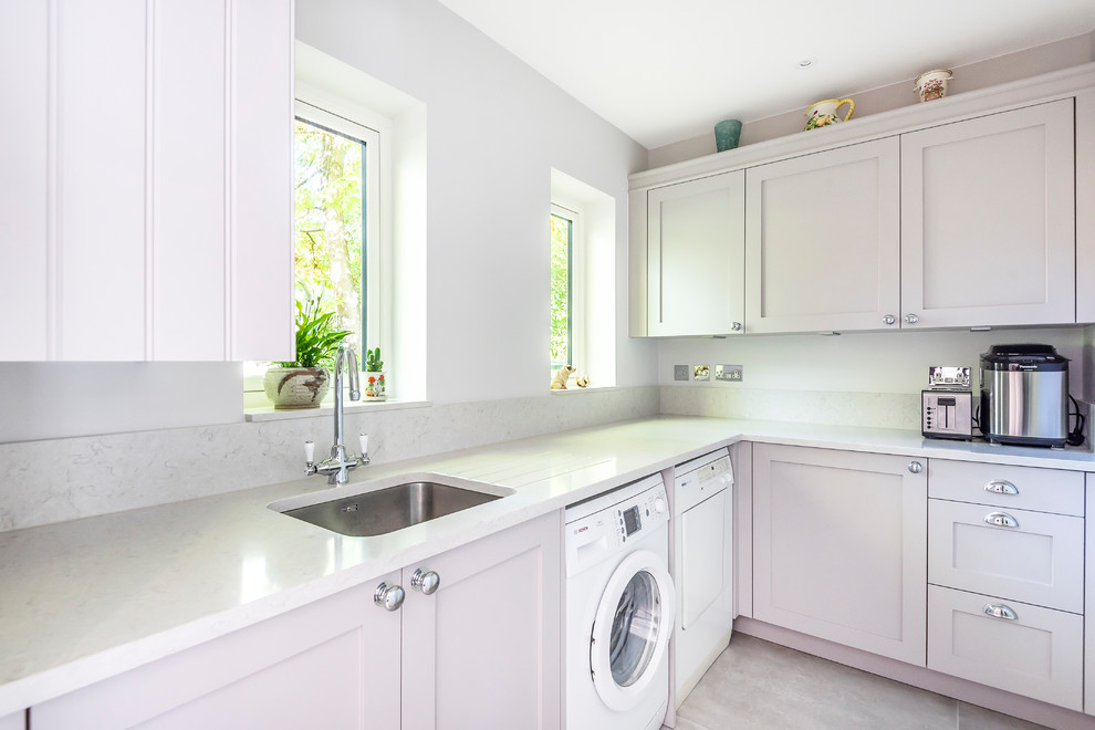 Design ideas for a traditional l-shaped utility room in Berkshire with a submerged sink, shaker cabinets, grey cabinets, white walls, a side by side washer and dryer, beige floors and white worktops.