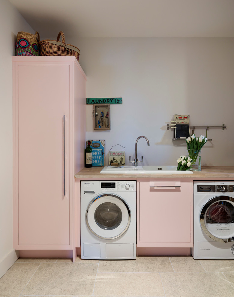 Ispirazione per una sala lavanderia chic con lavello da incasso, ante lisce, top in legno e lavatrice e asciugatrice affiancate