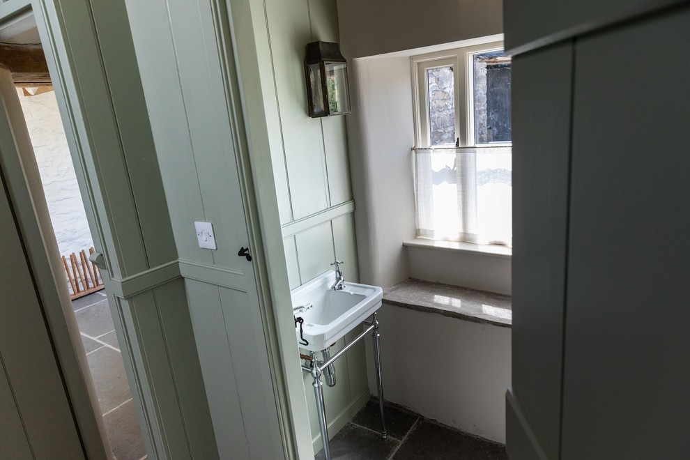 Exempel på en stor klassisk grå parallell grått tvättstuga enbart för tvätt, med en rustik diskho, skåp i shakerstil, gröna skåp, granitbänkskiva, vita väggar, skiffergolv, tvättmaskin och torktumlare byggt in i ett skåp och blått golv