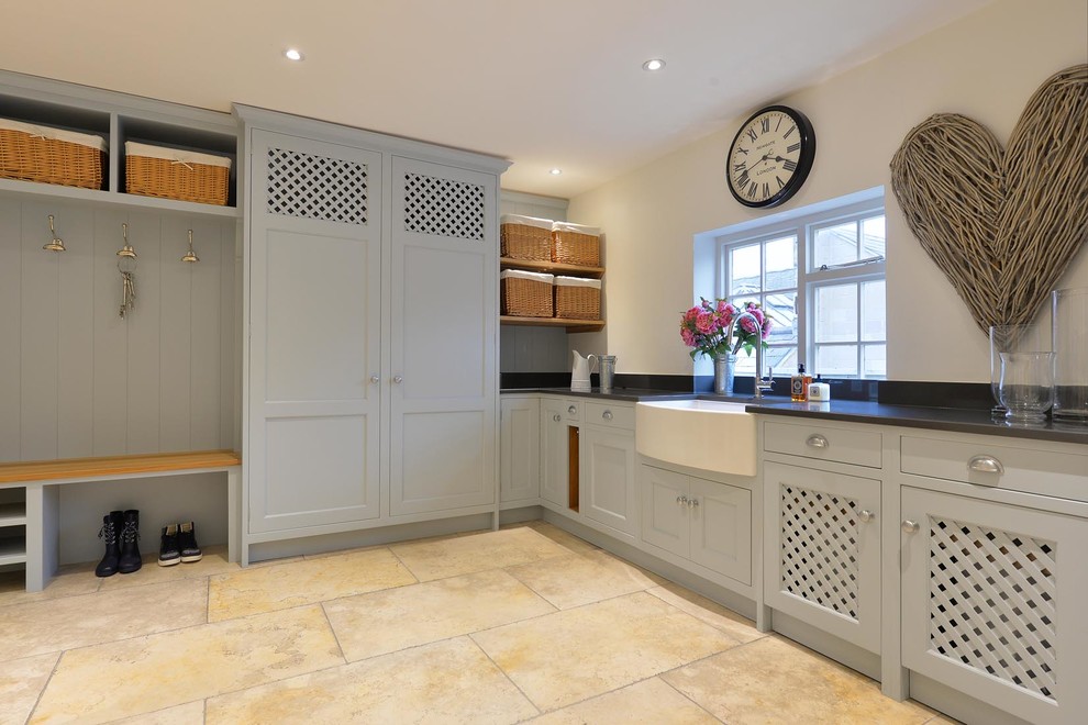 This is an example of a large contemporary utility room in Other with a belfast sink and limestone flooring.