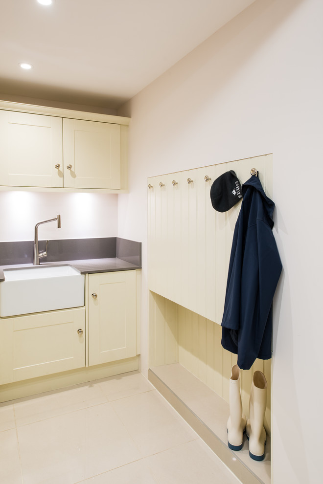 Immagine di una piccola lavanderia multiuso con lavello da incasso, ante lisce, ante beige, pareti bianche, lavatrice e asciugatrice affiancate e top grigio