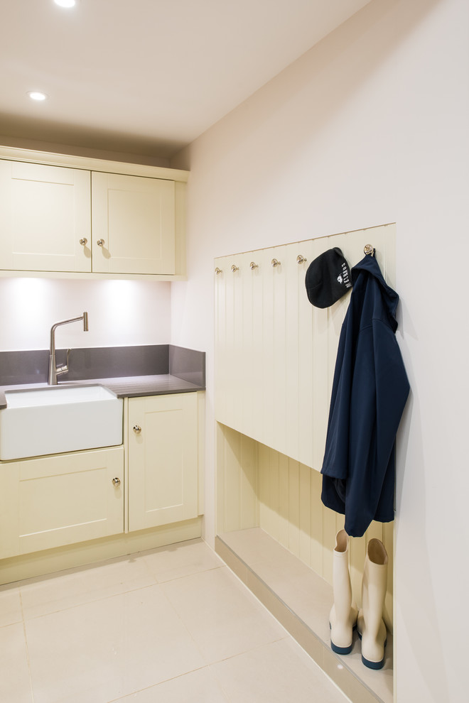 Photo of a small country l-shaped utility room in West Midlands with a belfast sink, shaker cabinets, beige cabinets, quartz worktops, beige walls, porcelain flooring and a side by side washer and dryer.
