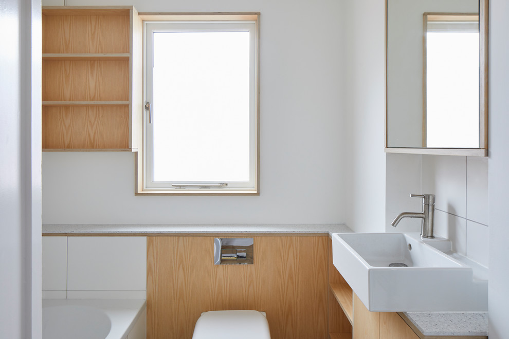 Foto di una lavanderia multiuso moderna con nessun'anta, ante in legno chiaro, top in superficie solida, pavimento in legno massello medio, lavatrice e asciugatrice nascoste, pavimento marrone e top giallo