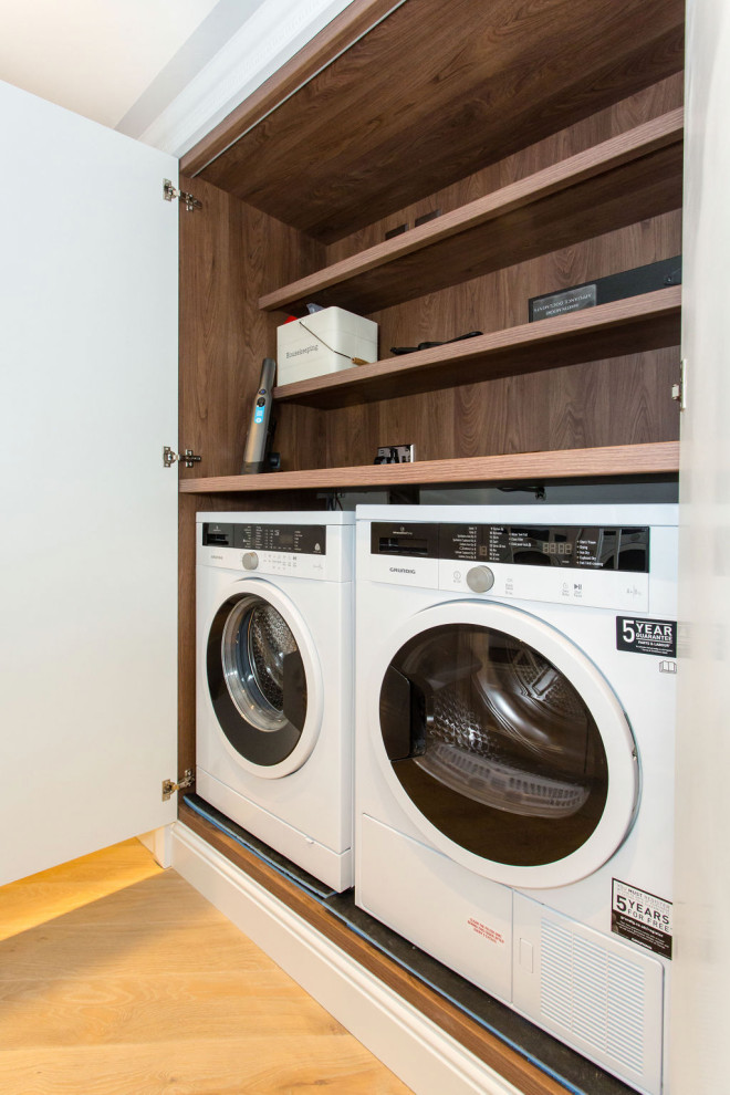 Foto de armario lavadero de galera contemporáneo pequeño con armarios con rebordes decorativos, puertas de armario blancas y encimera de madera