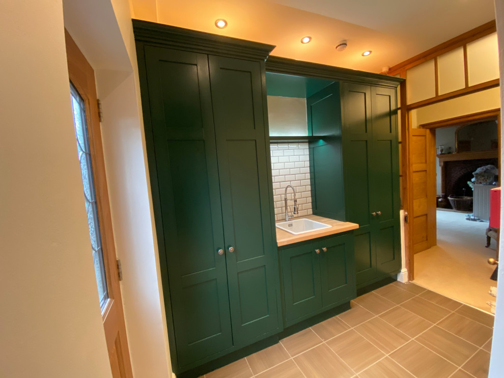 Classic utility room in West Midlands with a built-in sink, shaker cabinets, green cabinets, wood worktops and brown worktops.