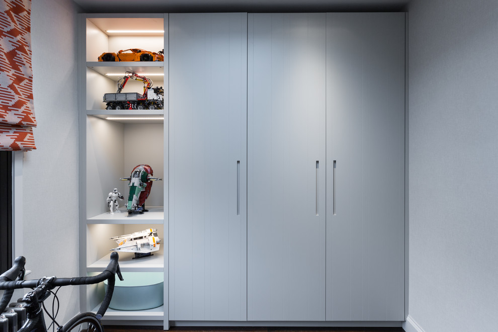 This is an example of a small contemporary single-wall utility room in Gloucestershire with flat-panel cabinets, grey cabinets, wood worktops, white walls, dark hardwood flooring, a concealed washer and dryer, brown floors and brown worktops.