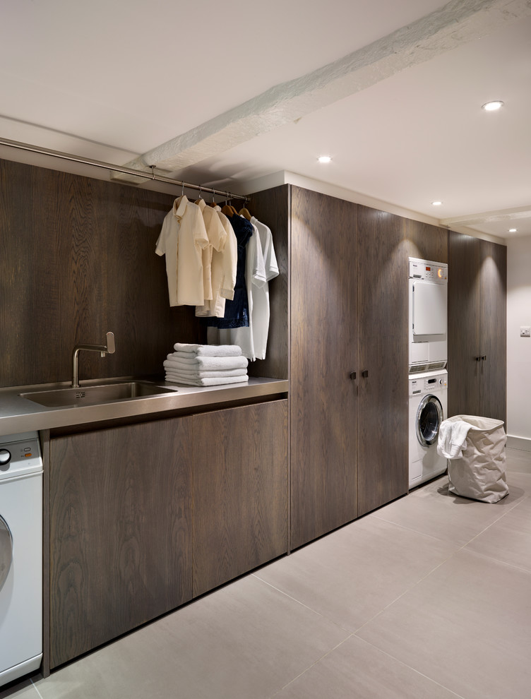 Moderne Waschküche mit integriertem Waschbecken, Waschmaschine und Trockner gestapelt, Edelstahl-Arbeitsplatte und grauer Arbeitsplatte in Sonstige