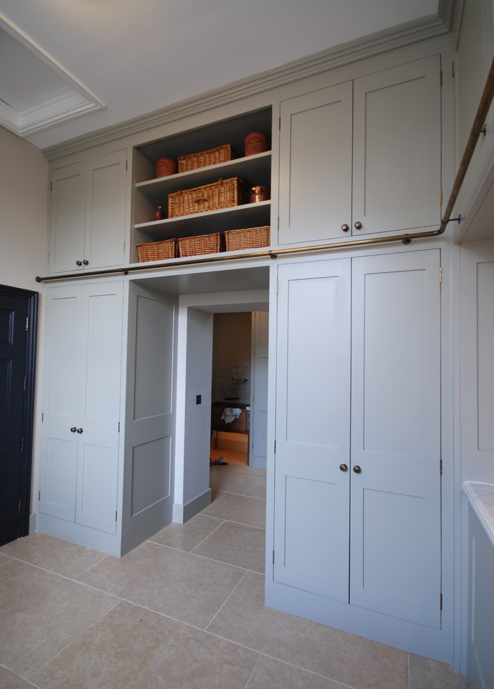Expansive traditional u-shaped utility room in West Midlands with a submerged sink, shaker cabinets, grey cabinets, marble worktops, grey walls, limestone flooring, a concealed washer and dryer, beige floors and white worktops.