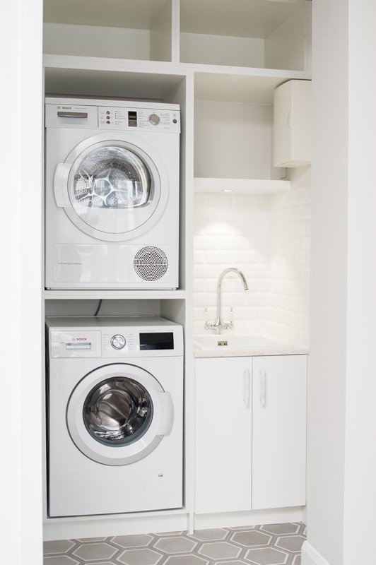 Imagen de lavadero lineal contemporáneo pequeño con fregadero bajoencimera, paredes blancas y suelo de cemento