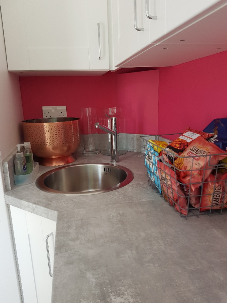 Kleiner Moderner Hauswirtschaftsraum mit Ausgussbecken, Schrankfronten im Shaker-Stil, weißen Schränken, Laminat-Arbeitsplatte, Küchenrückwand in Grau, rosa Wandfarbe, Linoleum, schwarzem Boden und grauer Arbeitsplatte in Essex