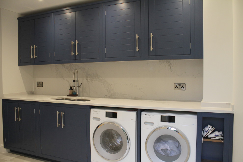 Inspiration for a large contemporary utility room in Hertfordshire with a built-in sink, quartz worktops, white walls, porcelain flooring, a side by side washer and dryer and beige floors.