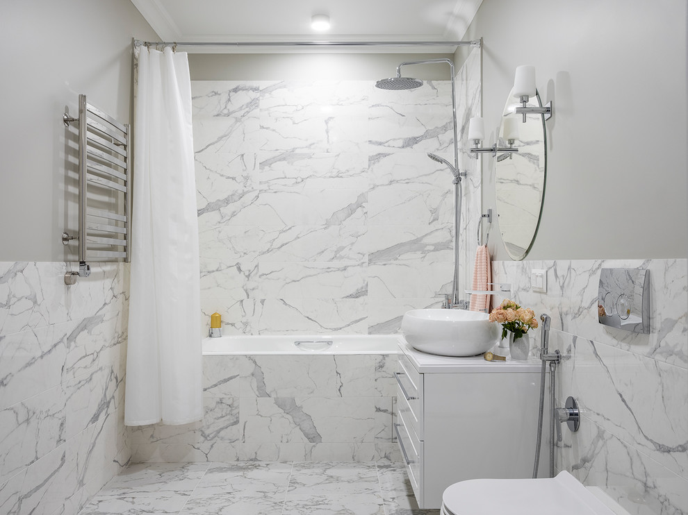 Klassisk inredning av ett vit vitt badrum med dusch, med skåp i shakerstil, vita skåp, en dusch/badkar-kombination, en vägghängd toalettstol, grå kakel, vit kakel, grå väggar, ett konsol handfat och vitt golv