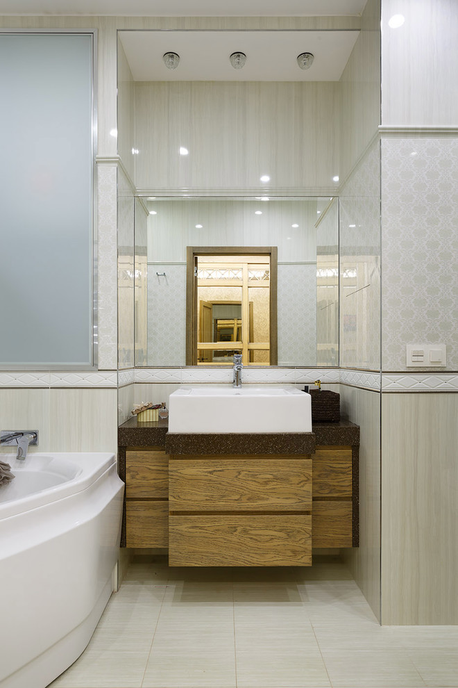 Inredning av ett modernt en-suite badrum, med släta luckor, skåp i mellenmörkt trä, ett hörnbadkar, beige kakel, vit kakel och ett fristående handfat