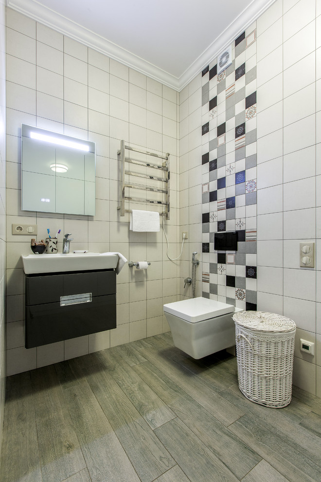 Ejemplo de cuarto de baño actual con armarios con paneles lisos, puertas de armario negras, sanitario de pared, baldosas y/o azulejos blancos, aseo y ducha y lavabo suspendido