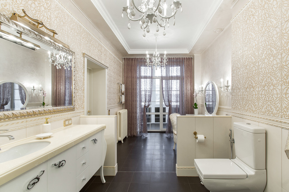 Idée de décoration pour une grande salle de bain principale tradition avec un placard à porte plane, des portes de placard blanches, WC séparés, un carrelage beige, un carrelage blanc et un lavabo encastré.