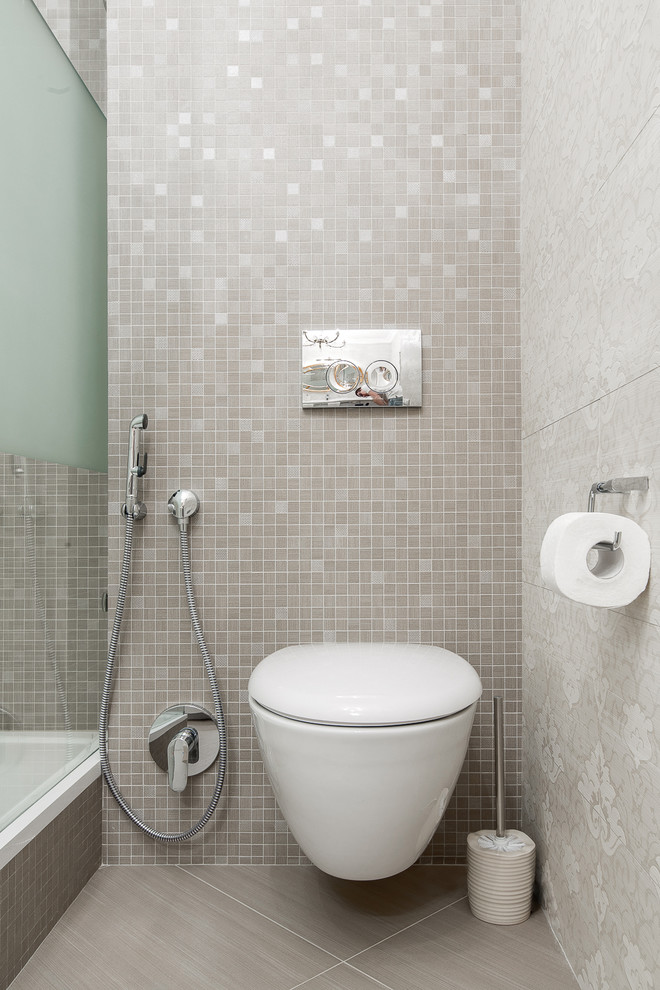Immagine di una stanza da bagno con doccia minimal con WC sospeso, piastrelle grigie, piastrelle a mosaico e pareti grigie