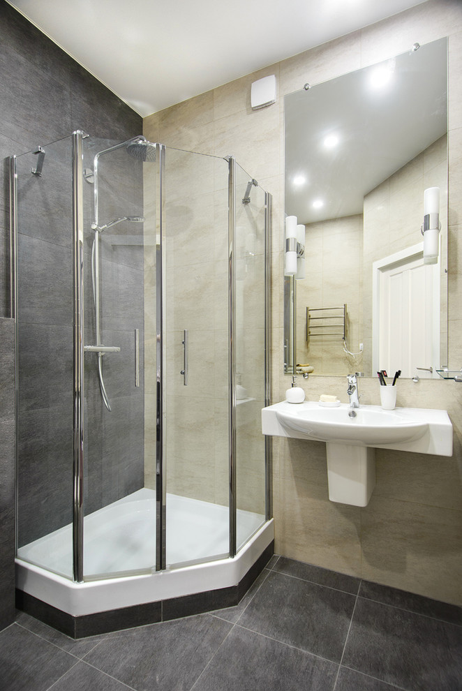Idéer för att renovera ett litet funkis badrum med dusch, med en hörndusch, en vägghängd toalettstol, grå kakel, porslinskakel, grå väggar, klinkergolv i keramik, ett väggmonterat handfat, grått golv och dusch med gångjärnsdörr