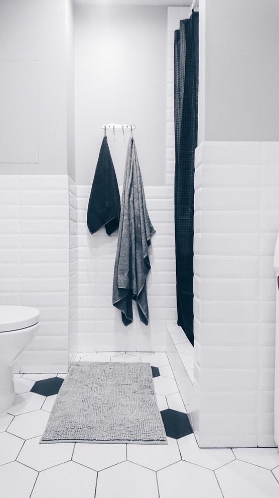 Foto di una stanza da bagno con doccia nordica di medie dimensioni con ante bianche, doccia alcova, piastrelle bianche, pareti bianche, pavimento bianco e doccia con tenda