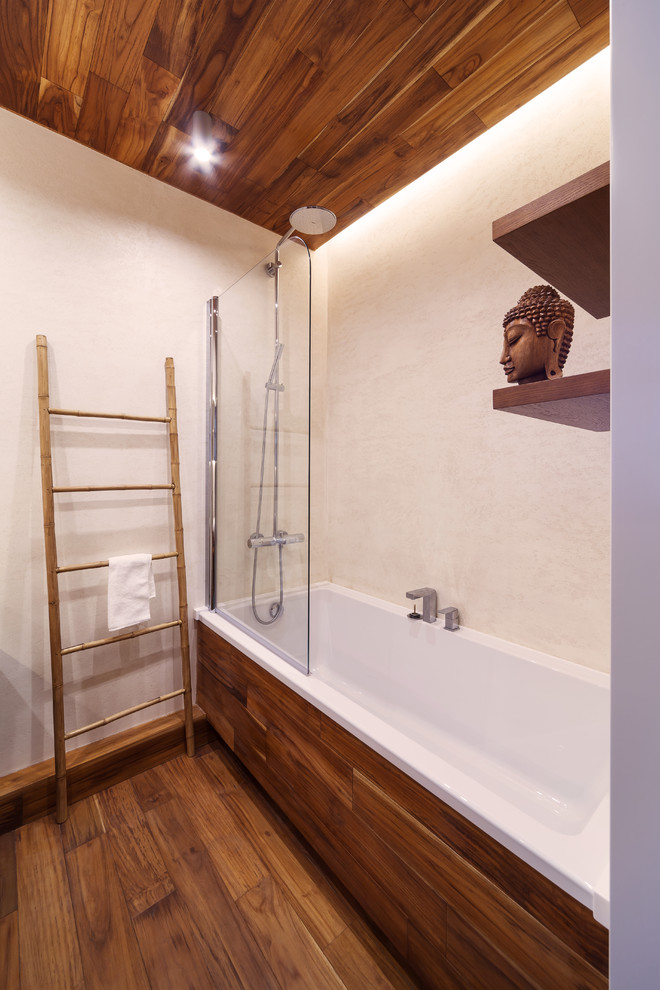 Идея дизайна: главная ванная комната среднего размера в современном стиле с ванной в нише, бежевыми стенами, деревянным полом и коричневым полом
