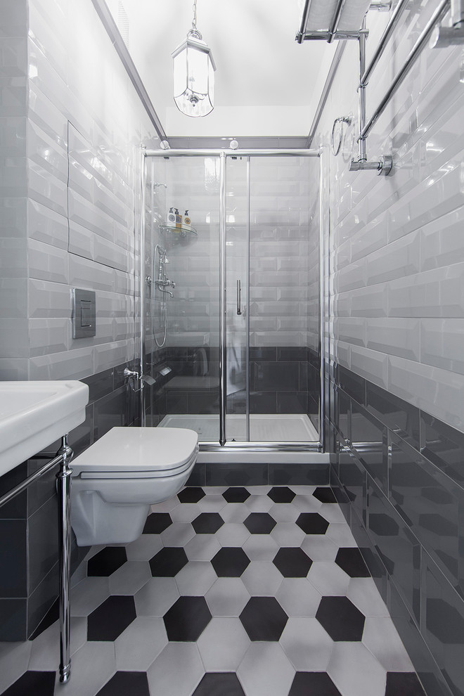 Ispirazione per una stretta e lunga stanza da bagno con doccia design con doccia alcova, WC sospeso, piastrelle grigie, lavabo a consolle, pavimento grigio e porta doccia scorrevole