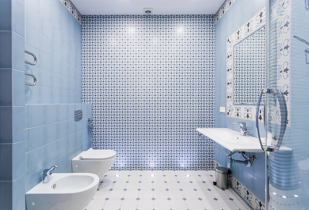 Modelo de cuarto de baño actual grande con bidé, baldosas y/o azulejos de cerámica, suelo de baldosas de porcelana, suelo blanco, lavabo suspendido, baldosas y/o azulejos azules, baldosas y/o azulejos blancos y paredes azules