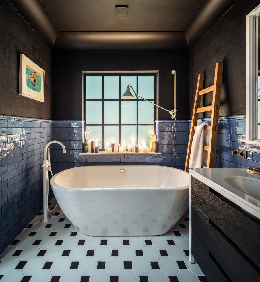 Idéer för mellanstora funkis vitt en-suite badrum, med släta luckor, svarta skåp, ett fristående badkar, blå kakel, tunnelbanekakel, svarta väggar, klinkergolv i porslin, ett avlångt handfat och flerfärgat golv