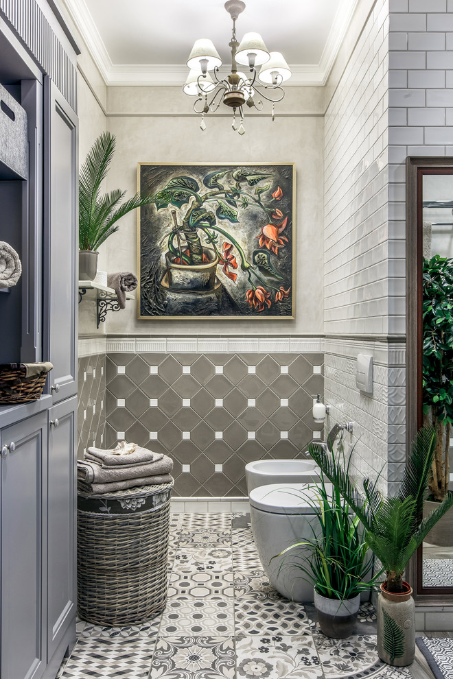 Пример оригинального дизайна: ванная комната среднего размера в стиле неоклассика (современная классика) с серыми фасадами, полновстраиваемой ванной, душем без бортиков, бежевыми стенами, полом из керамогранита, бежевым полом и открытым душем