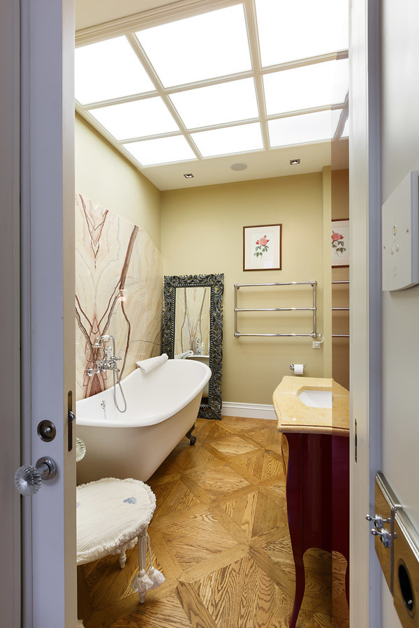 Exempel på ett klassiskt badrum, med ett badkar med tassar, beige väggar, mellanmörkt trägolv och ett undermonterad handfat