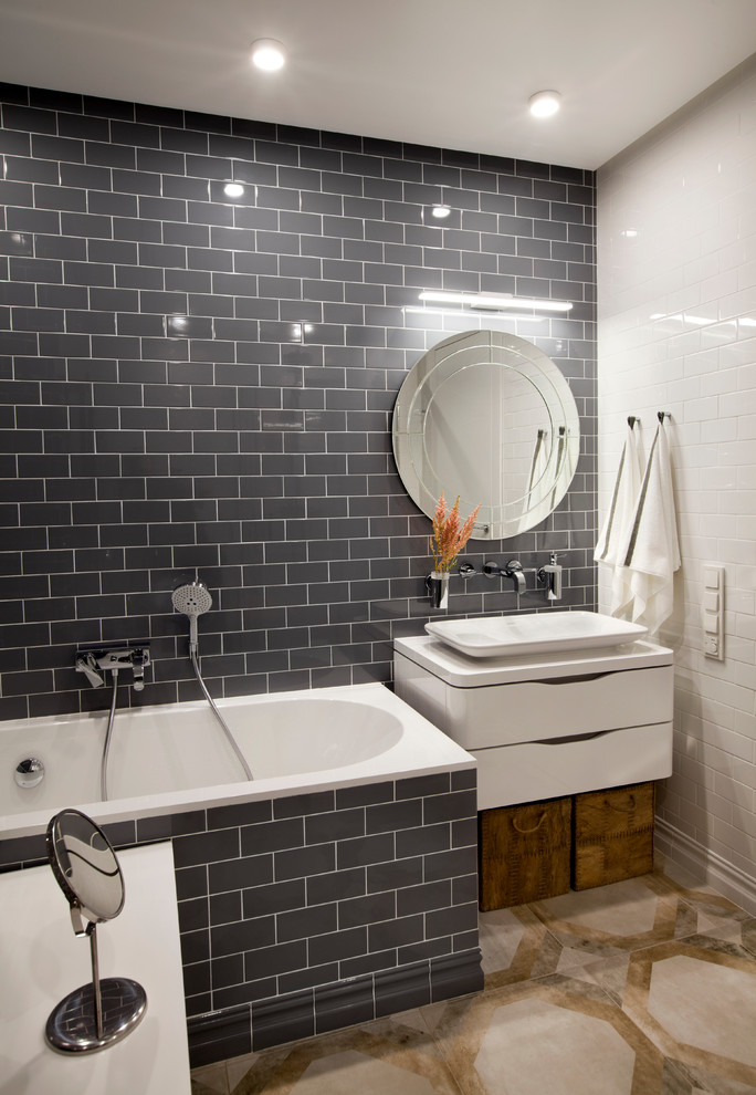 Modern inredning av ett mellanstort en-suite badrum, med släta luckor, vita skåp, ett platsbyggt badkar, en dusch/badkar-kombination, vit kakel, grå kakel och ett fristående handfat