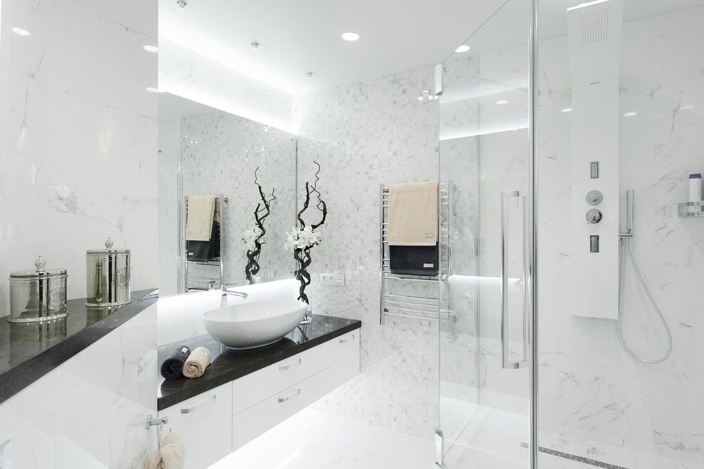 На фото: ванная комната в современном стиле с плоскими фасадами, белыми фасадами, белой плиткой, душевой кабиной, настольной раковиной, белым полом, душем с распашными дверями и черной столешницей с