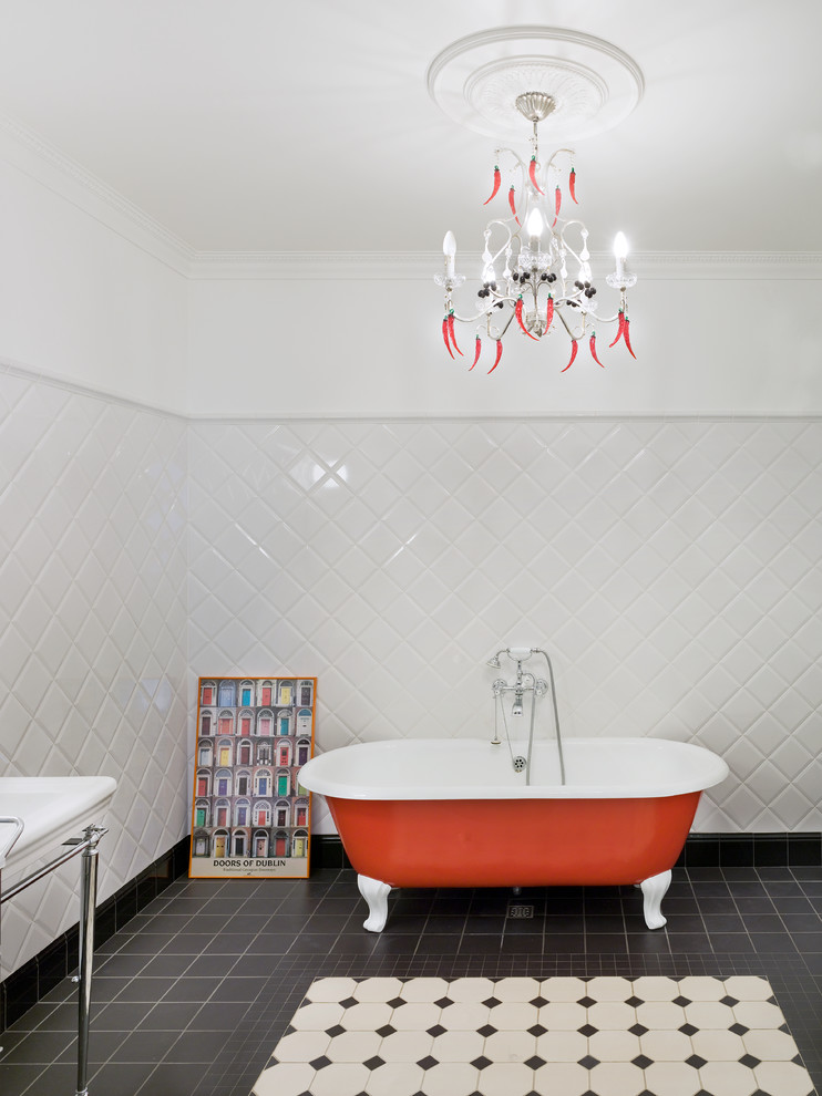 На фото: ванная комната в современном стиле с ванной на ножках, белыми стенами, консольной раковиной и черно-белой плиткой
