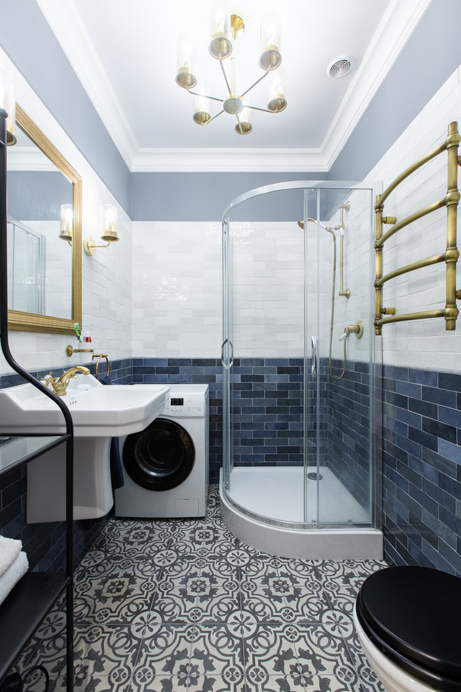 На фото: ванная комната в скандинавском стиле с открытыми фасадами, угловым душем, раздельным унитазом, синей плиткой, белой плиткой, серыми стенами, душевой кабиной, подвесной раковиной, разноцветным полом и душем с распашными дверями с