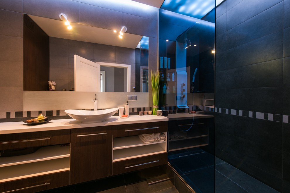 Свежая идея для дизайна: ванная комната в современном стиле с плоскими фасадами, душем в нише, серой плиткой, душевой кабиной, настольной раковиной, темными деревянными фасадами и открытым душем - отличное фото интерьера